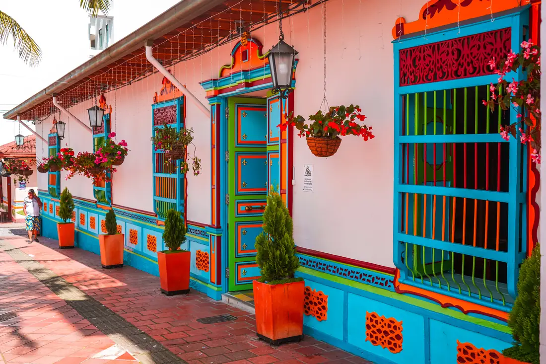 Fachada de la Casa Cural, blanca con puertas, ventanas y zócalos de colores.
