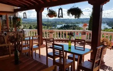 Mesas de un restaurante con terraza y vista al embalse de Guatapé.